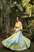 Woman in a traditional outfit standing in a garden with palm trees