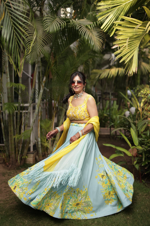 Woman in a traditional outfit standing in a garden with palm trees